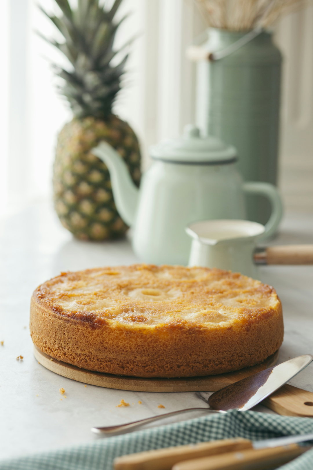 a-cake-sitting-on-top-of-a-table-next-to-a-pineapple.jpg a cake sitting on top of a table next to a pineapple